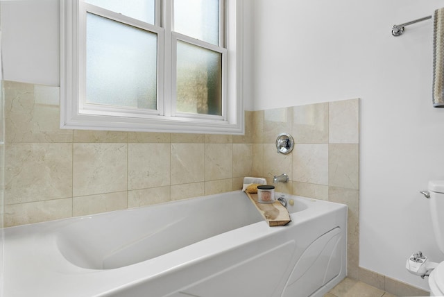 bathroom with toilet, a bath, and tile patterned floors