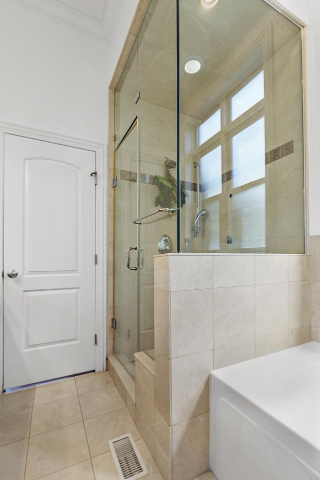 full bath featuring crown molding, a shower stall, and tile patterned floors