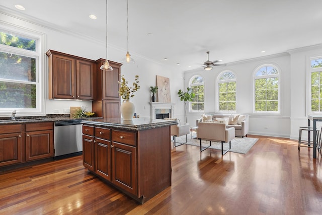 kitchen featuring dishwasher, a sink, dark wood-style flooring, a fireplace, and ceiling fan