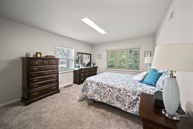 bedroom featuring carpet, baseboards, visible vents, and a skylight