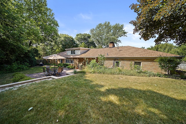 back of property featuring a patio, a chimney, and a lawn