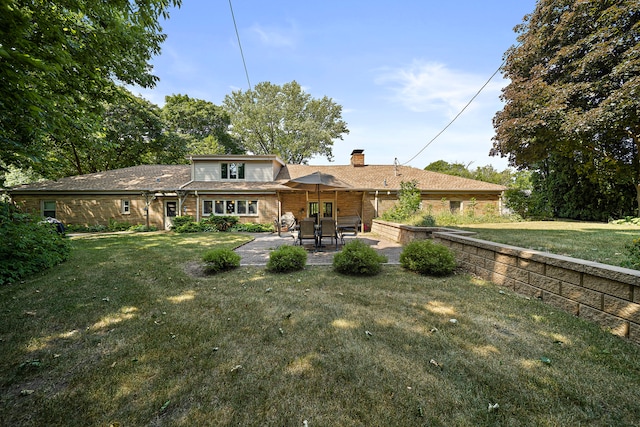 rear view of house with a yard, a patio area, and a chimney