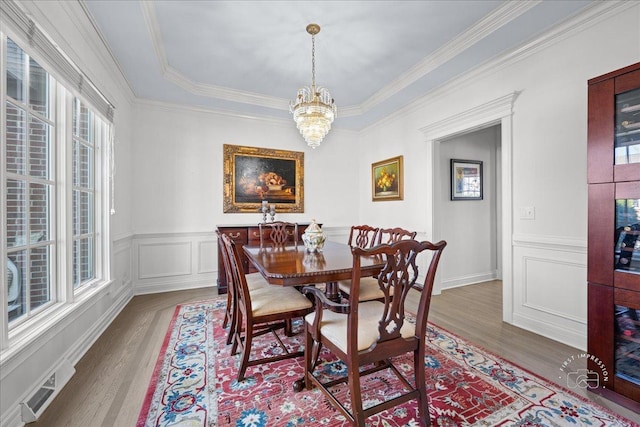 1651 Eagle Brook Dr, Geneva, IL 60134 - dining room featuring wood finished floors, visible vents, crown molding, wainscoting, and a notable chandelier