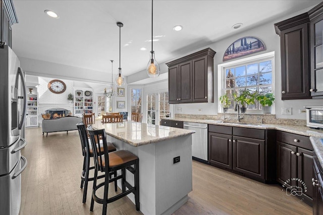 1651 Eagle Brook Dr, Geneva, IL 60134 - kitchen with dark brown cabinets, a sink, open floor plan, a large fireplace, and stainless steel appliances