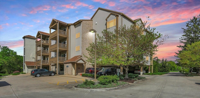 property at dusk featuring uncovered parking