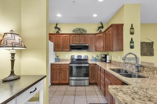 kitchen featuring light tile patterned flooring, light stone countertops, recessed lighting, a sink, and stainless steel appliances