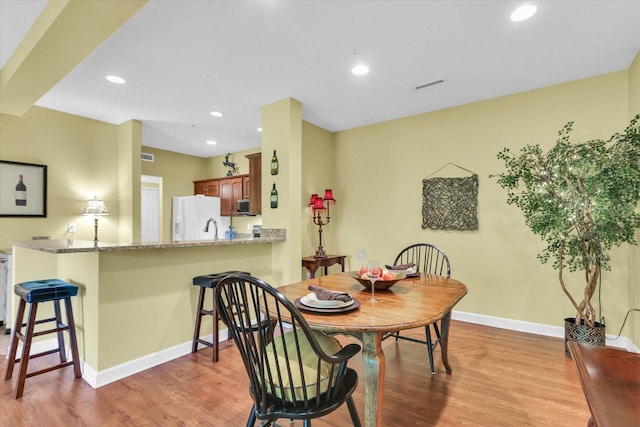 dining space with baseboards, recessed lighting, light wood-style flooring, and visible vents