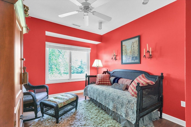 bedroom featuring baseboards, ceiling fan, wood finished floors, and visible vents