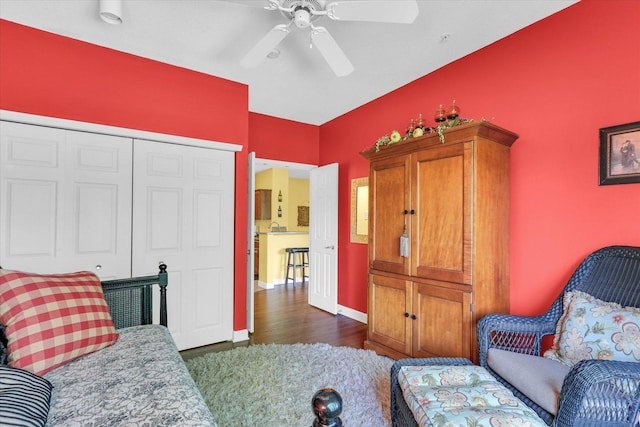 living area featuring baseboards, dark wood-style flooring, and ceiling fan
