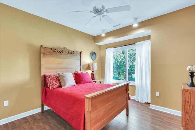 bedroom with visible vents, baseboards, ceiling fan, and wood finished floors