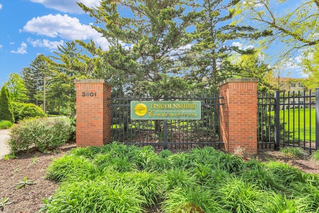 community / neighborhood sign featuring fence