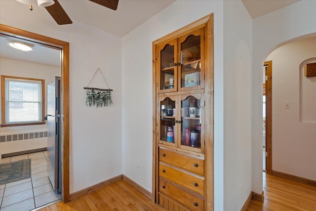 418 Bonnie Brae Ave, Itasca, IL 60143 - corridor with radiator, arched walkways, baseboards, and light wood-style flooring
