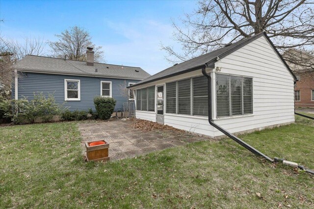 418 Bonnie Brae Ave, Itasca, IL 60143 - rear view of house with a chimney, a lawn, a shingled roof, a patio, and a sunroom