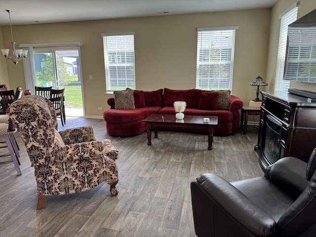 living room featuring baseboards, wood finished floors, and a chandelier