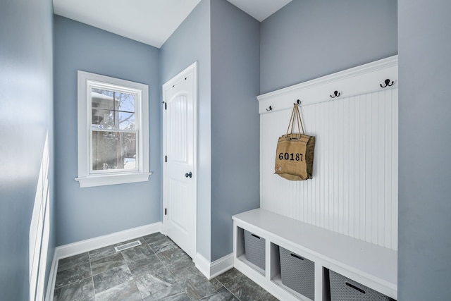 mudroom featuring marble finish floor, baseboards, and visible vents