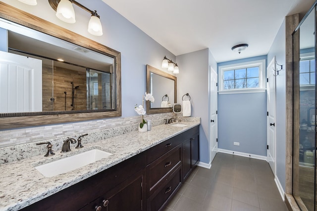 full bathroom with tile patterned flooring, baseboards, a stall shower, and a sink