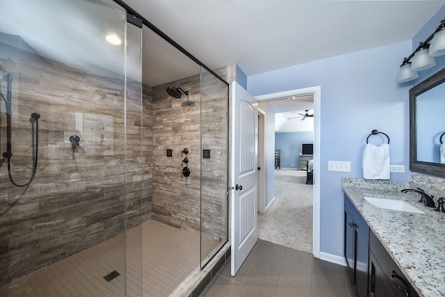 ensuite bathroom with vanity, tile patterned flooring, a shower stall, and connected bathroom