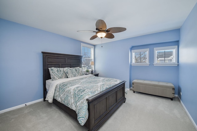 bedroom with a ceiling fan, baseboards, and light colored carpet