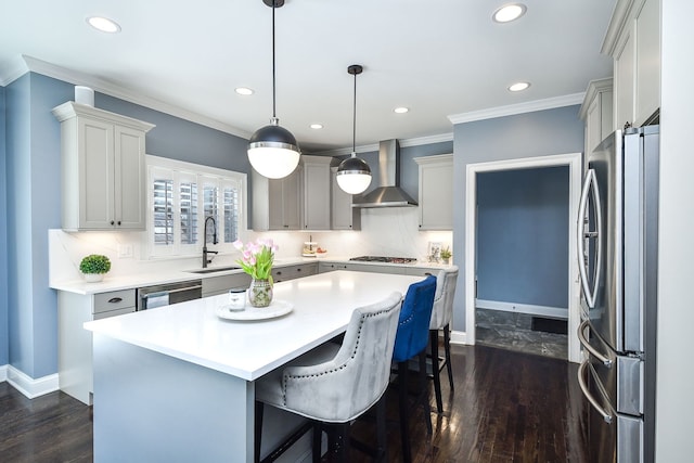 kitchen with wall chimney range hood, a center island, stainless steel appliances, and recessed lighting