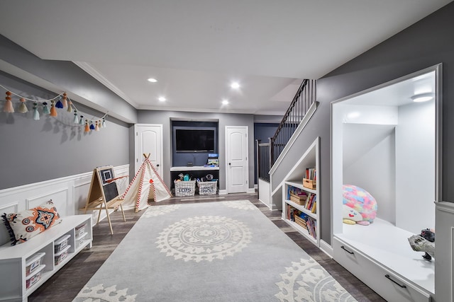 game room with crown molding, a wainscoted wall, dark wood-style floors, and recessed lighting