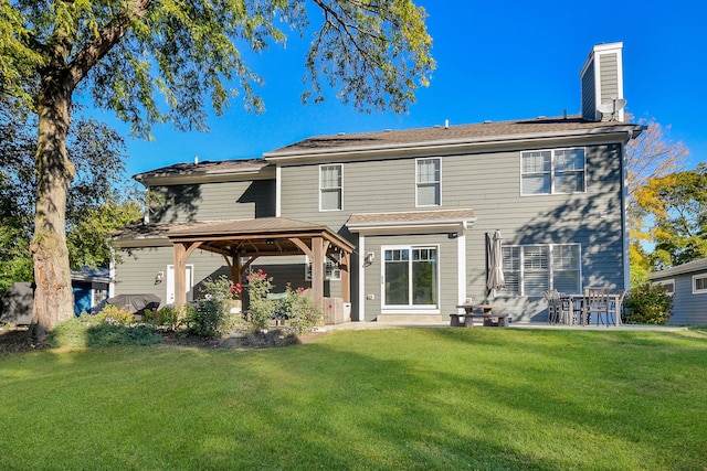 back of property with a lawn, a chimney, a gazebo, and a patio