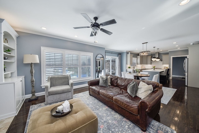 living area with a ceiling fan, dark wood-type flooring, and ornamental molding
