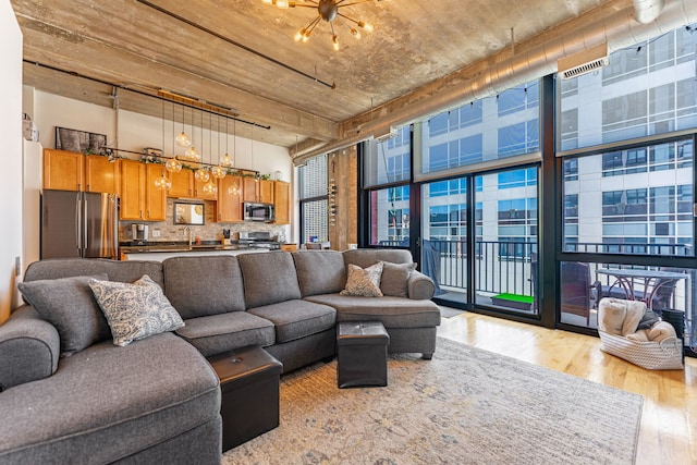 living room with an inviting chandelier and light wood-style flooring