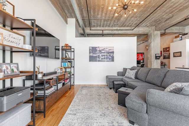 living room featuring baseboards, wood finished floors, and a chandelier