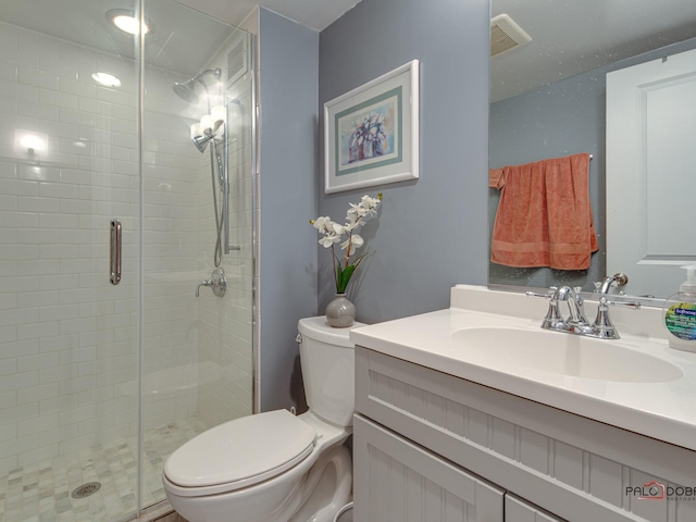 full bath with visible vents, vanity, a shower stall, and toilet