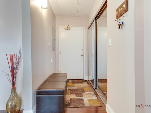 hall featuring electric panel, wood finished floors, and a textured ceiling