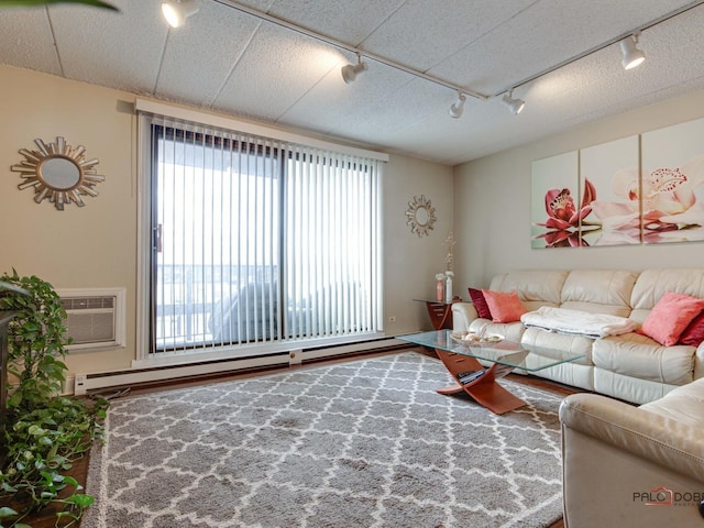 living room featuring a baseboard heating unit, track lighting, and a wall mounted air conditioner