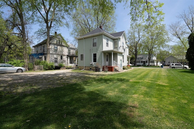 765 N Main St, Pontiac, IL 61764 - view of side of property featuring a chimney and a lawn