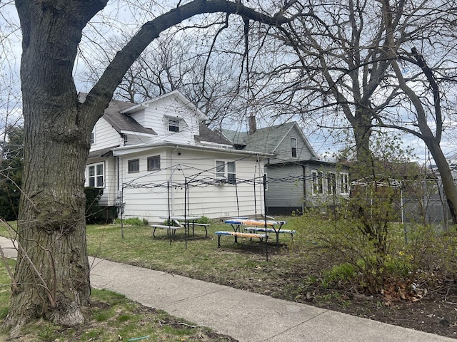 1702 Lincoln St, North Chicago, IL 60064 - view of home's exterior with a trampoline, a lawn, and a shingled roof