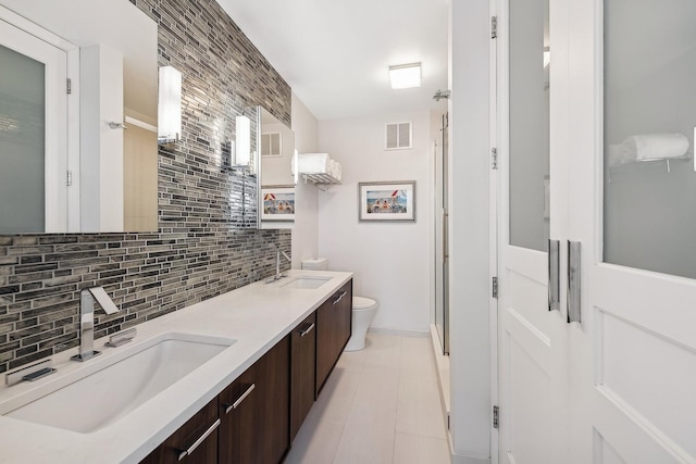 bathroom with tasteful backsplash, visible vents, toilet, and a sink