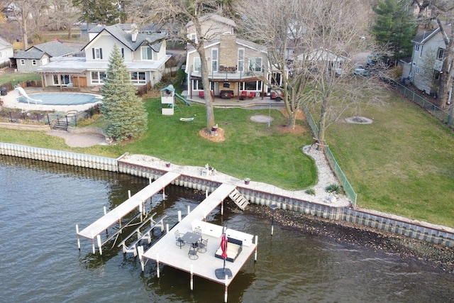 view of dock with a yard, boat lift, and a water view