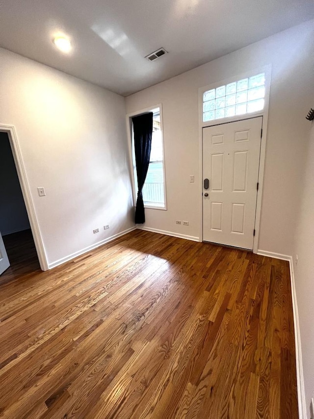 entrance foyer featuring baseboards, visible vents, wood finished floors, and plenty of natural light