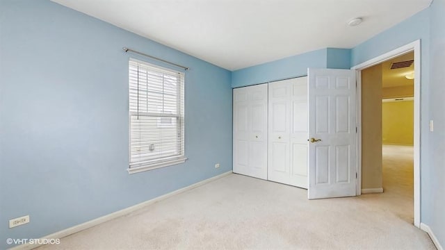 unfurnished bedroom with carpet floors, a closet, visible vents, and baseboards