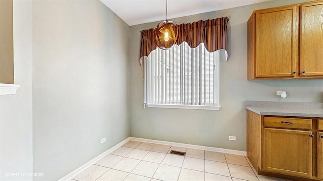 unfurnished dining area with visible vents, baseboards, and light tile patterned floors