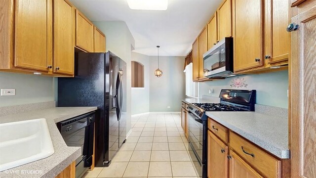 kitchen with light countertops, light tile patterned floors, arched walkways, a sink, and black appliances