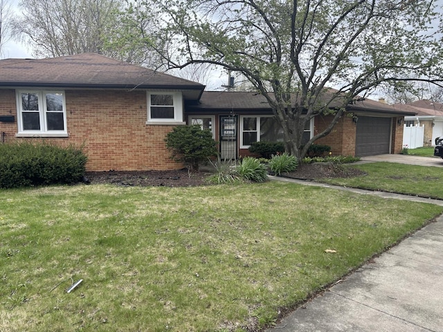 view of front of property featuring a garage, brick siding, a front lawn, and driveway