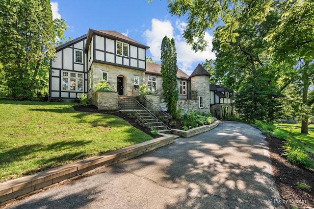 109 3rd Ave, Montgomery, IL 60538 - english style home with stone siding, a front lawn, and stucco siding