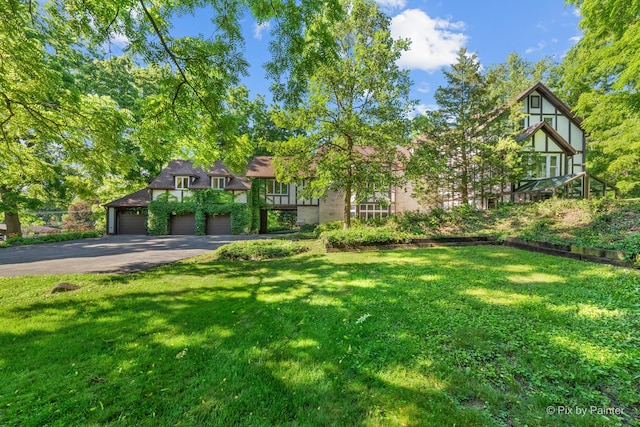 109 3rd Ave, Montgomery, IL 60538 - tudor home featuring asphalt driveway, a front lawn, and an attached garage