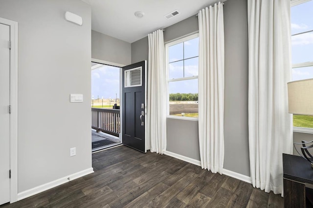 entryway featuring baseboards, visible vents, and dark wood finished floors