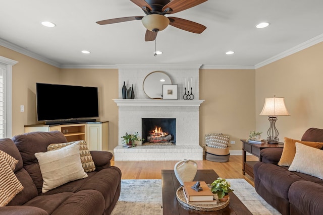 living room with crown molding, ceiling fan, a fireplace, recessed lighting, and wood finished floors