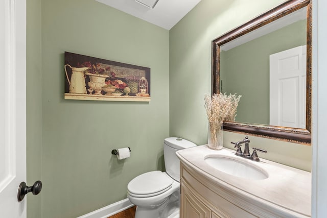 half bath featuring toilet, baseboards, wood finished floors, and vanity