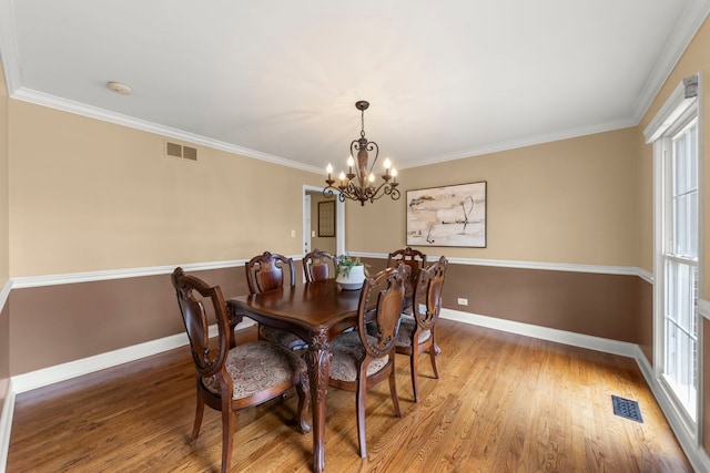dining area featuring visible vents, light wood-style floors, baseboards, and an inviting chandelier