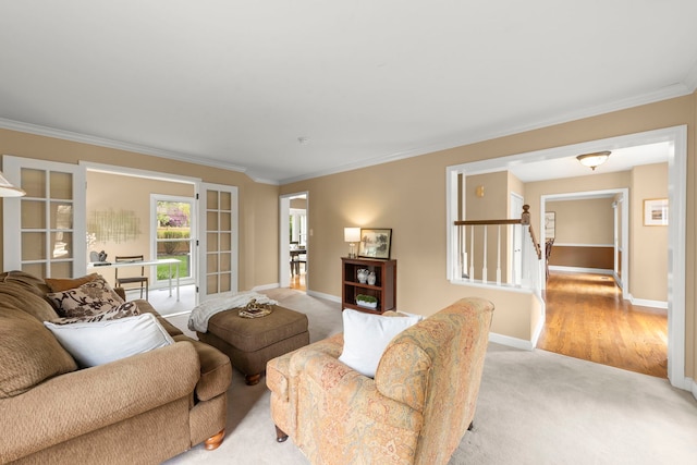 living area featuring crown molding, baseboards, and light carpet
