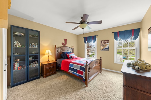 bedroom with baseboards, ceiling fan, and light colored carpet