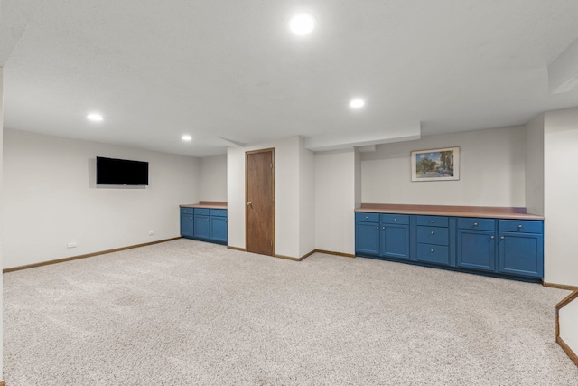 finished below grade area featuring recessed lighting, baseboards, and light colored carpet