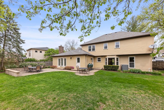 back of house featuring a lawn, a fenced backyard, and central AC